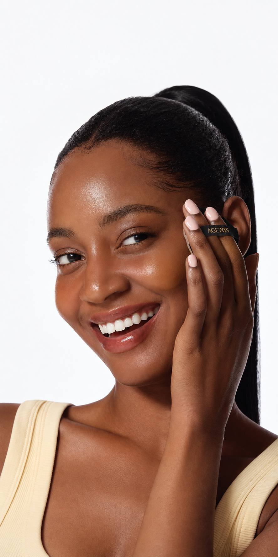Close-up beauty portrait of a smiling woman applying AGE20’S cushion foundation with a puff, highlighting a radiant, dewy complexion.